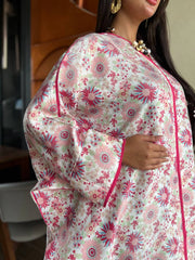 Woman wearing a floral dress with pink and green patterns.