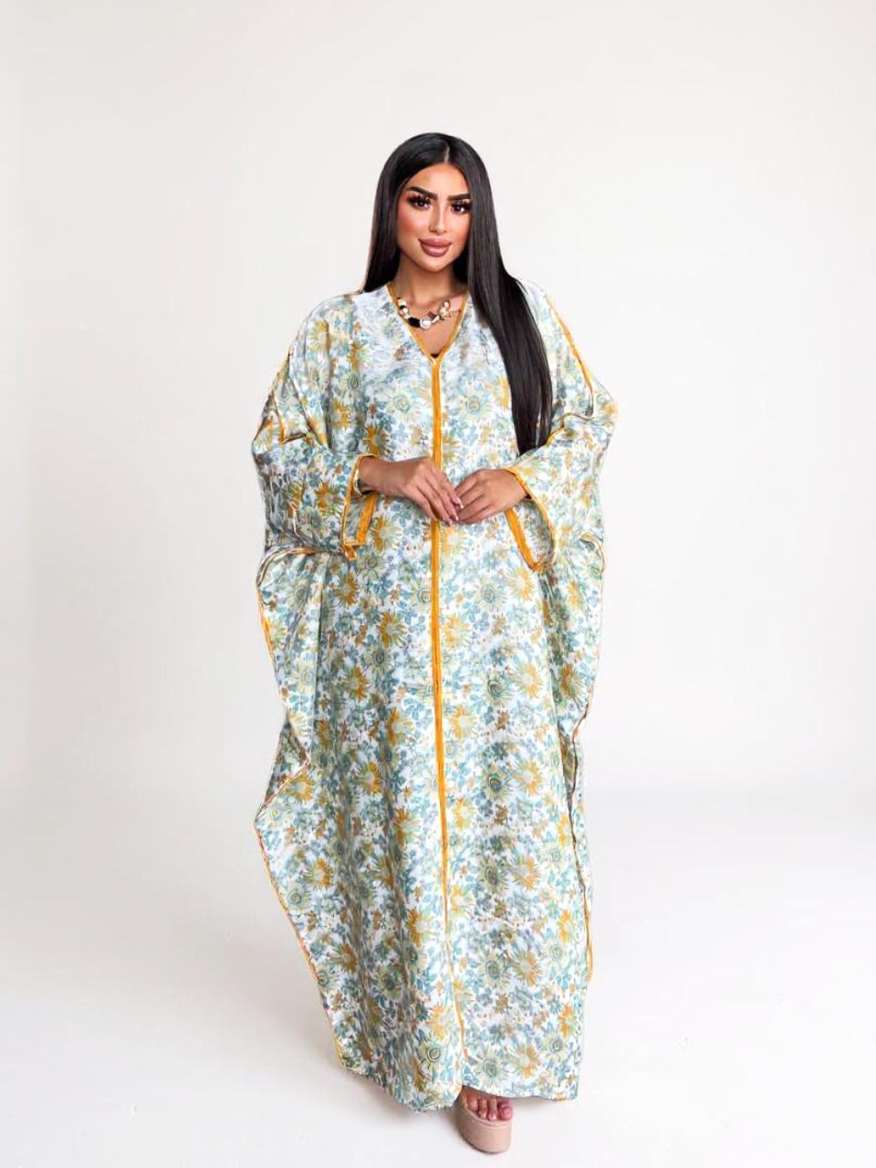 Woman wearing a floral dress with a yellow zipper on a white background