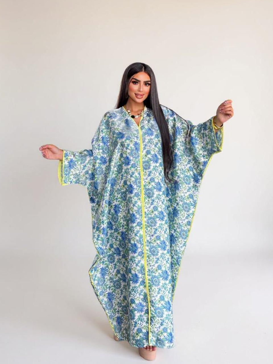 Woman wearing a floral dress with a yellow zipper on a white background